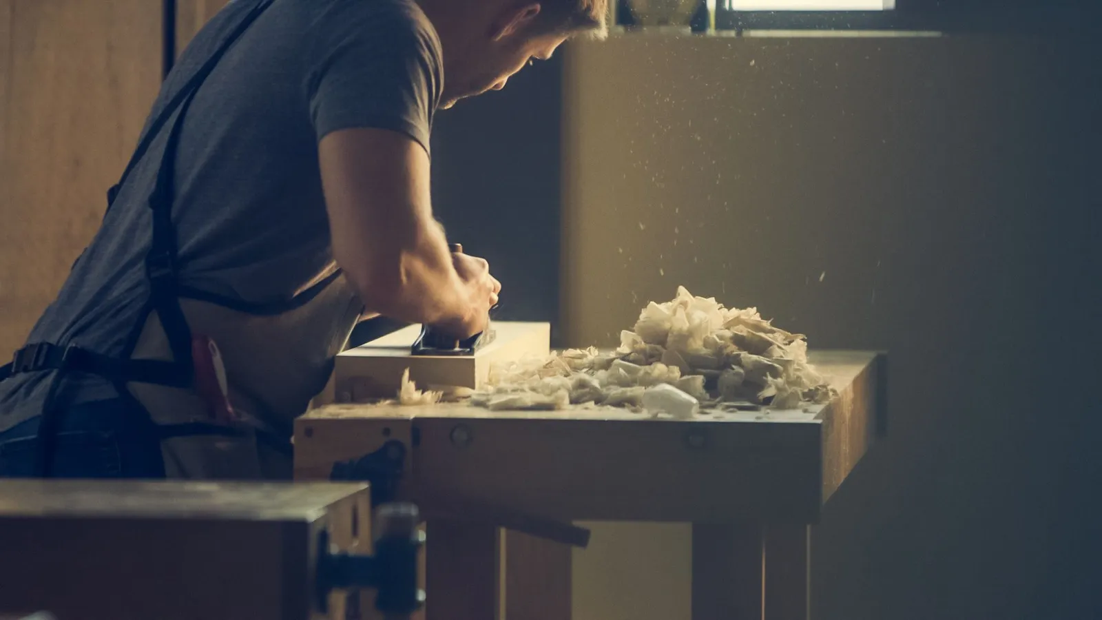 Falegname al lavoro su un tavolo in legno massello